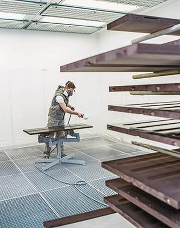 Person die Holz lackiert